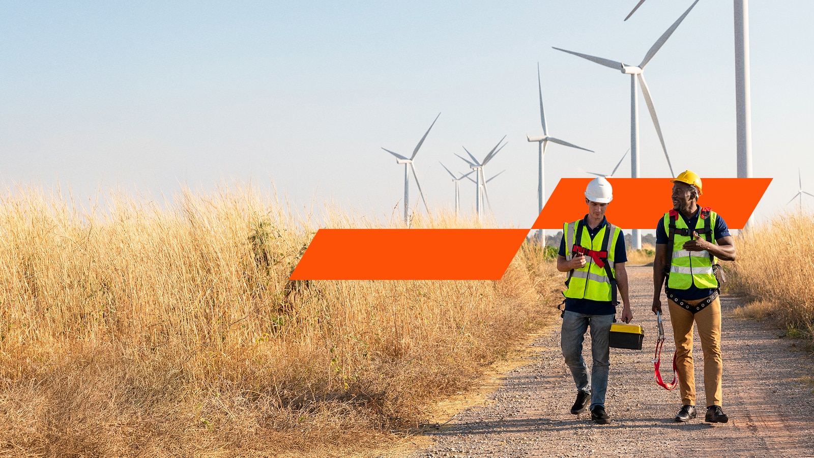 Two workers walking on a road in field