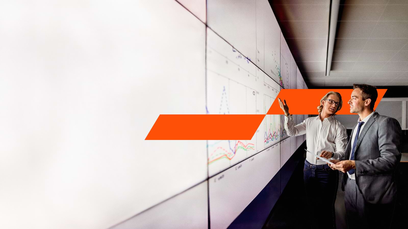 Two man looking at a graph on a board