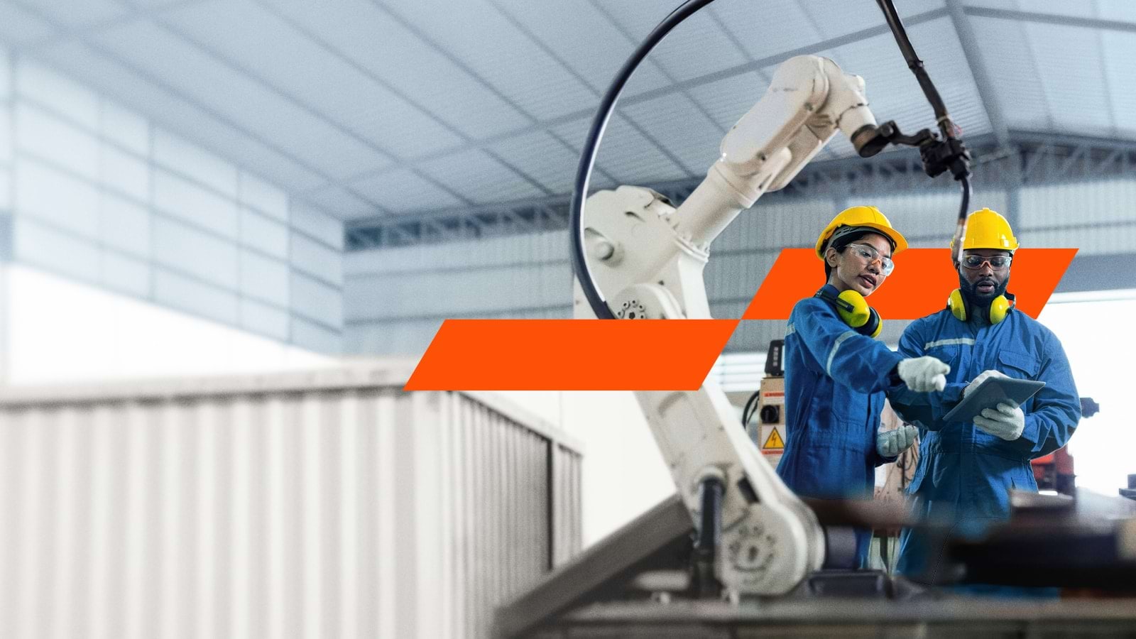 Two workers next to robotic arm